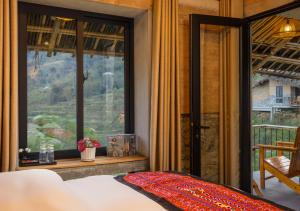 a bedroom with a bed and a large window at Sapaxa Spring Garden Ecolodge in Sapa