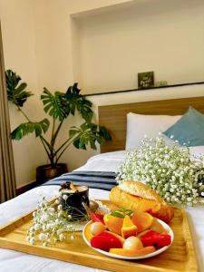 a tray with a plate of food on a bed at K HO DISCOVERY Guest House in Da Lat