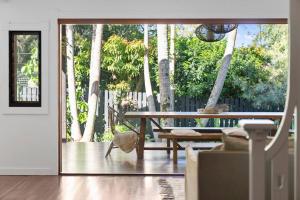 un soggiorno con tavolo e un patio alberato di Bangalow Beauty - Stunning Home - Magnesium Pool a Bangalow