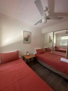 a room with two beds and a mirror at Surfers Tradewinds in Gold Coast +43 photos