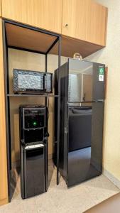 a kitchen with a refrigerator and a microwave at Cottonwood Villa Magnolia B - Jacuzzi Billyard BBQ in Bandung