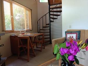 a living room with a table and a spiral staircase at Cabañas Ecotrébol in Nobsa