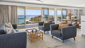 ein Wohnzimmer mit Stühlen und Meerblick in der Unterkunft Convent Cove - Penthouse with views over Convent in Yamba