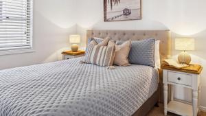 ein Schlafzimmer mit einem Bett mit zwei Nachttischen und zwei Lampen in der Unterkunft Convent Cove - Penthouse with views over Convent in Yamba