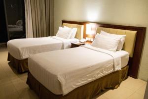 Ένα ή περισσότερα κρεβάτια σε δωμάτιο στο Thong's Inn Hotel Kualanamu