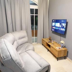 Una sala de estar con una silla y un televisor. en Juan Dolio,Beach, Pool, 40"TV , Optic Internet, Relax, en Villas del Mar