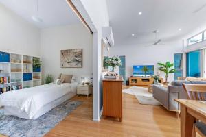 a bedroom with a bed and a living room at Large, Luxurious Townhouse Stunning Oceanviews in Airlie Beach +14 photos