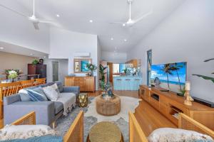 a living room with a couch and a tv at Large, Luxurious Townhouse Stunning Oceanviews in Airlie Beach