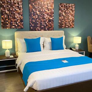 a bedroom with a blue and white bed with two lamps at Fynn Boutique Hotel in Bacoor