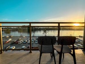a balcony with two chairs and a view of a marina at Nausori Plaza Hotel in Vunimono