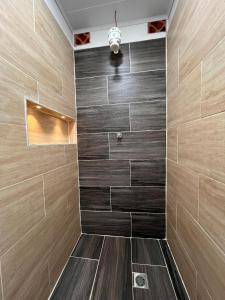 a walk in shower with brown tile and a light at Cabaña ideal 5-9 personas cocina, wifi, cerca al parque y campestre in Jardin +69 photos