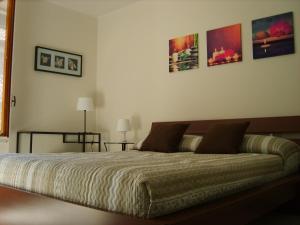 Un dormitorio con una cama y algunos cuadros en la pared. en Il Teatro, en Bérgamo