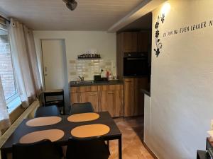 a kitchen with a table and chairs in a room at Vakantiehuis chaletje in Lanaken