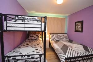zwei Etagenbetten in einem Zimmer mit lila Wänden in der Unterkunft Riverview Holiday Apartment 25 - Kalbarri, WA in Kalbarri + 8 Fotos