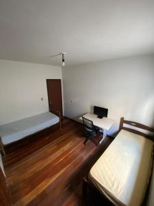 una habitación con una cama y un escritorio con una computadora en República Favela, en Ouro Preto 6 fotos más