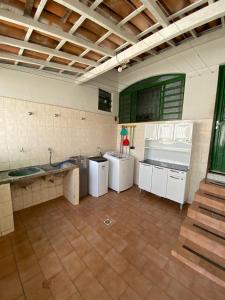cocina grande con armarios blancos y suelo de baldosa en República Favela, en Ouro Preto