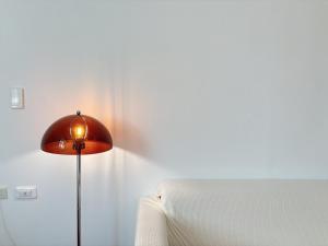 a red lamp sitting next to a bed in a room at 過家家民宿GoHouse花蓮市包棟寵物友善 in Hualien City