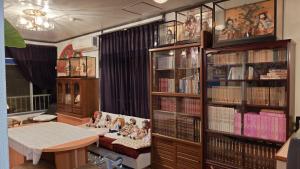 soggiorno con tavolo e librerie con libri di 三介荘 a Izunokuni