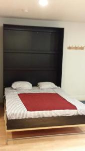 坎贝尔Private nicely decorated studio的一张带黑色床头板和红色毯子的床