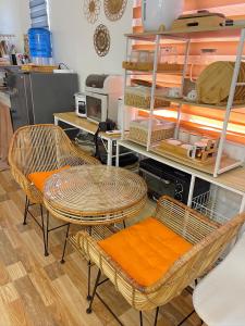 - 2 chaises en osier et une table dans une pièce dans l'établissement Olango Island - S&E-1 Tiny Guest House Fully Furnished with Hot Shower, Washer, Wi-Fi, Netflix & King-size Bed, à Lapu Lapu City 1 autre photo
