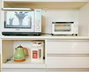 a kitchen with two microwaves and a microwave at 富士山を眺められる宿 ゲストハウス花水木 in Nishikatsuracho