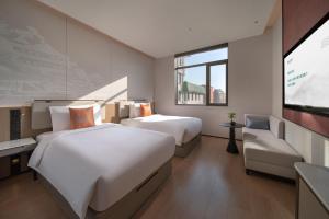 a hotel room with two beds and a flat screen tv at SSAW Garden Hotel Beijing in Beijing +50 photos