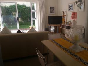 una sala de estar con un sofá y una mesa en H4 Princess Beach duplex, en Ciudad del Cabo