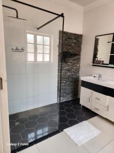 a bathroom with a shower and a sink at Sunshine Inn in Gaborone