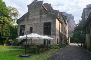 a building with an umbrella and tables and chairs at Yangshuo Sugar House in Yangshuo