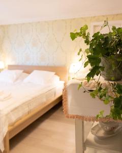 a bedroom with a bed and a potted plant at Rauhalahden Kartano in Kuopio