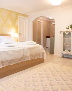 a bedroom with a large bed and a kitchen at Rauhalahden Kartano in Kuopio +11 photos