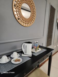 a mirror on a wall above a black table with food at Sunshine Inn in Gaborone +44 photos