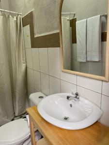 a bathroom with a sink and a toilet and a mirror at Residencia Boho in San Pedro La Laguna +23 photos