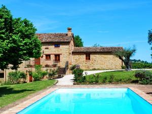 a house with a swimming pool in front of a building at Agriturismo Elisei in Gualdo di Macerata