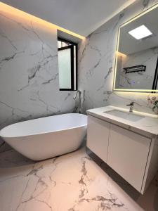 a bathroom with a white tub and a sink at XinTianDi 3 Bedrooms Newly Luxury Designer Decoration Intelligent Control System in Shanghai