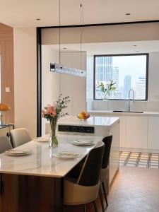 a kitchen with a table with chairs and a counter top at XinTianDi 3 Bedrooms Newly Luxury Designer Decoration Intelligent Control System in Shanghai +15 photos