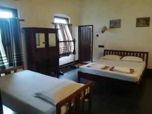 アレッピーにあるAlleppey Tharavadのベッド2台と窓のある寝室 +12枚の写真