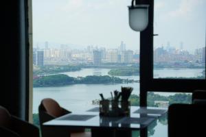 un tavolo in una stanza con vista sul fiume di 南昌象湖格兰云天大酒店 a Taohua