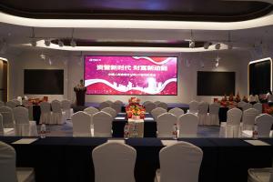 una sala conferenze con sedie bianche e uno schermo di proiezione di 南昌象湖格兰云天大酒店 a Taohua