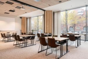 a dining room with tables and chairs and large windows at Solo Sokos Hotel Pier 4 in Helsinki