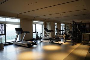 una palestra con tapis roulant e attrezzature per il fitness in un edificio di 南昌象湖格兰云天大酒店 a Taohua