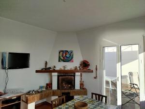 a living room with a fireplace and a television at Bellavista in Santa Flavia