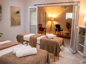 Una habitación con tres camas con toallas. en NamaStay, en Ciudad del Cabo