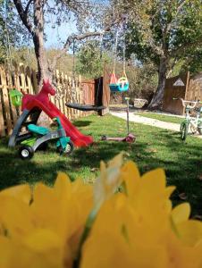 a toy horse on a tricycle in the grass next to a swing at Мехса in Svetoslav