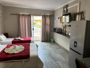 a hotel room with two beds and a kitchen at Karas-inn Bed and Breakfast in Karasburg