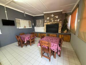 comedor con 2 mesas y chimenea en Karas-inn Bed and Breakfast, en Karasburg