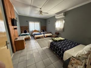 Un dormitorio con dos camas y una sala de estar. en Karas-inn Bed and Breakfast, en Karasburg
