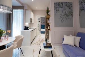 a living room with a blue couch and a table at Le Cinque Lampade Florence Suites in Florence