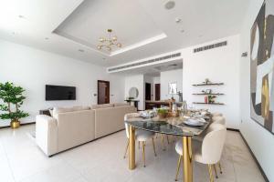 a dining room with a table and a couch at Frank Porter - Diamond, Tiara Residences in Dubai +24 photos