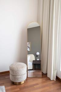 a mirror in a room with a chair and a stool at Frank Porter - Diamond, Tiara Residences in Dubai